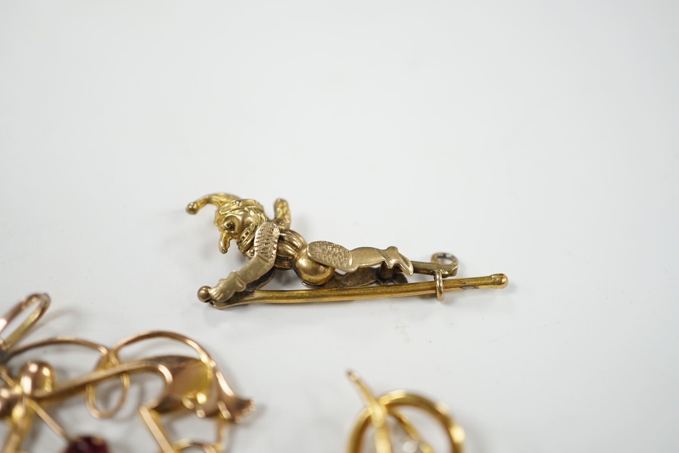 An Art Nouveau yellow metal and two stone gem set drop pendant, 53mm, an articulated Mr Punch charm and a modern 9ct gold and diamond chip set serpent stick pin.